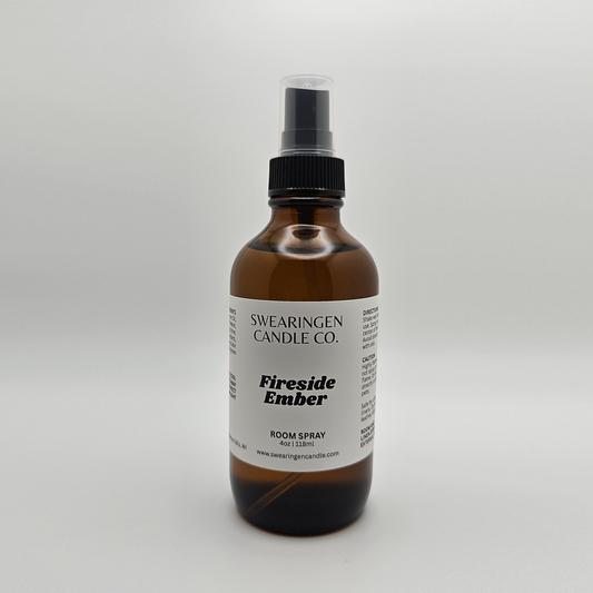 Fireside Ember hand-poured odor eliminating room spray in an amber glass spray bottle, shown from the front - Swearingen Candle Co.